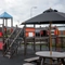 The exterior children's play area at The Parsonage in Leigh, with a picnic table and shade umbrella.