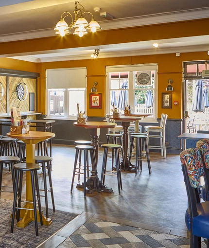 The interior restaurant seating area with pub game dartboards at The Yacht.