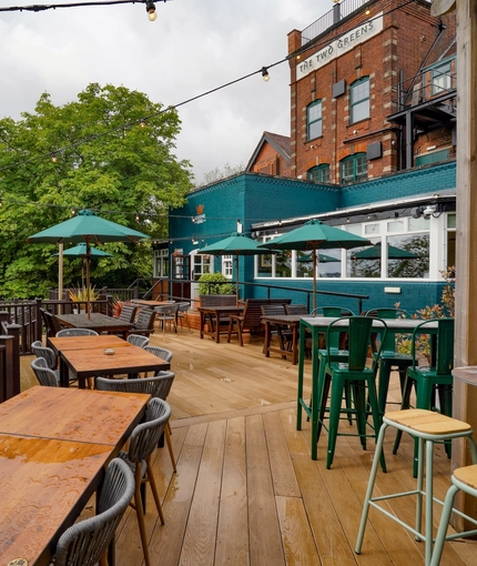 The exterior beer garden seating area and rear of the venue The Two Greens.