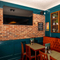 An interior restaurant seating area of the Lucas Arms in London, with upholstered booth seating and a TV on the wall.