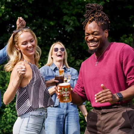 An exterior shot of a group of people with various drinks during the Q3 Live Music Event at one of the Greene King Pubs.
