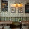 Two tables in the restaurant of The Rockingham Arms, next to a plant.