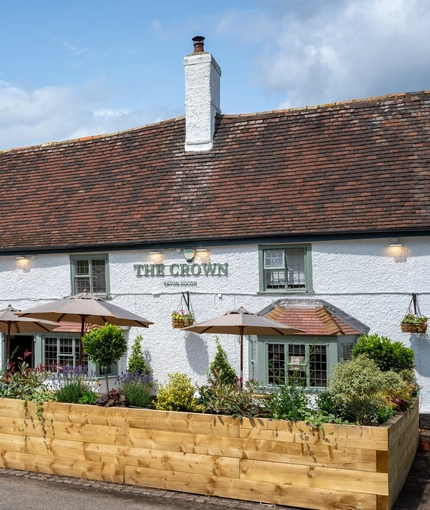 The exterior facade with seating area at the Crown Inn.