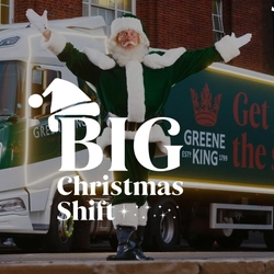 A banner showing the words "Big Christmas Shift" on top of an image of Santa Claus standing in front of a  Greene King truck with both of his arms raised up.