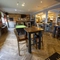 Interior dining area of a pub with a pool table, a TV and a gambling machine.