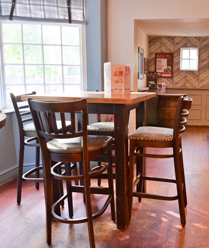 Interior dining are of a pub with a TV and a pool table.