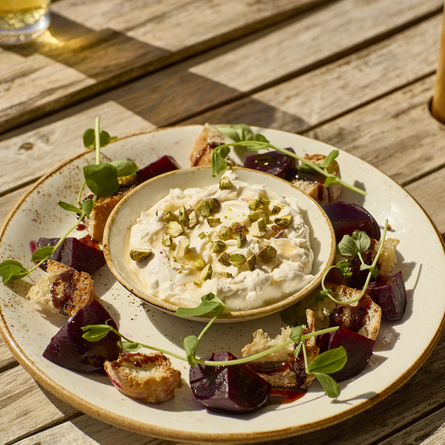 An image showing the whipped goats cheese and sticky barbeque chicken served on a plate at Chef & Brewer.