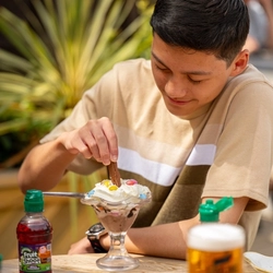 A family seated at an outdoor table in a beer garden, enjoying a dessert..