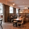 Interior dining area of a pub with a TV playing tennis.