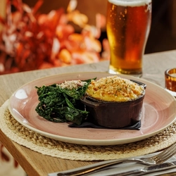 An advertising image of a Pie Choice dish and a pint of beer within the interior restaurant and seating area at The Foundry Bell.
