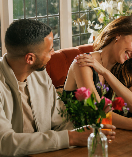 An image focusing on 3 customers sat with friends enjoying Valentines Day Drinks sat at a table within the interior seating area of The Crown.