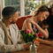 An image focusing on 3 customers sat with friends enjoying Valentines Day Drinks sat at a table within the interior seating area of The Crown.