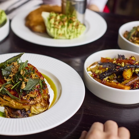 A selection of Main dishes and a glass of white wine sat on a table available at Metro venues.