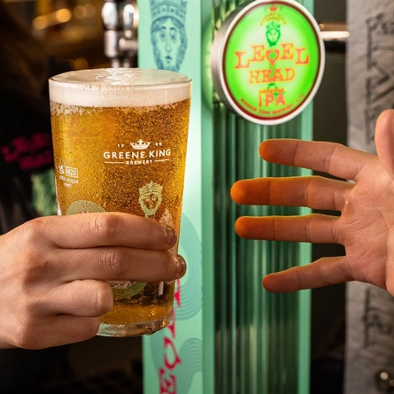 A pint of Level Head being passed to a customer at a Nest venue.