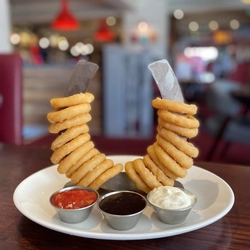 A plate of onion rings on a wooden table