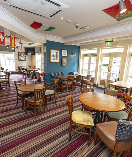 Interior dining area of a pub with a TV.