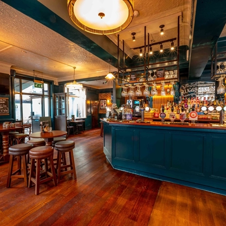 The interior bar and restaurant seating area with TV screen and advertising chalkboard at The Lucas Arms.