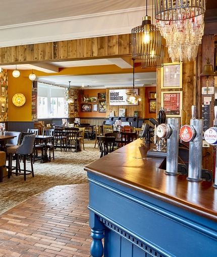 The bar and interior restaurant seating area with TV at the Fox and Crown.