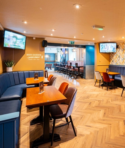 The interior seating area with two TVs on the wall at the Armstrongs.