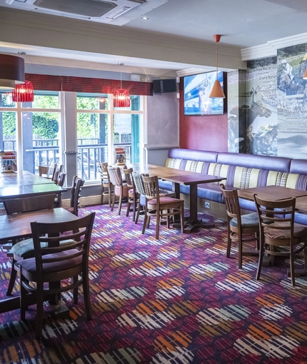 Interior dining area of a pub with TVs.