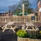 An exterior beer garden seating area at The Green Posts, with wooden picnic tables, and plants in wooden planter boxes.
