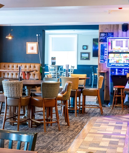 Interior dining area of a pub with a gambling machine.
