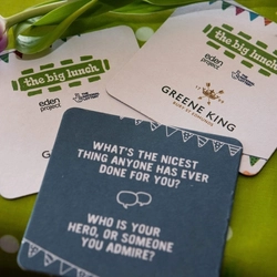 Greene King beer mats on a table.