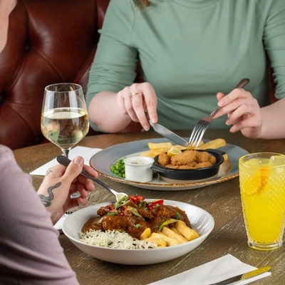 People seated at a table with plated food and drinks.