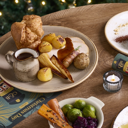 A banner showing several Festive Spread dishes sat on a table within the interior restaurant seating area at a Chef & Brewer venue.