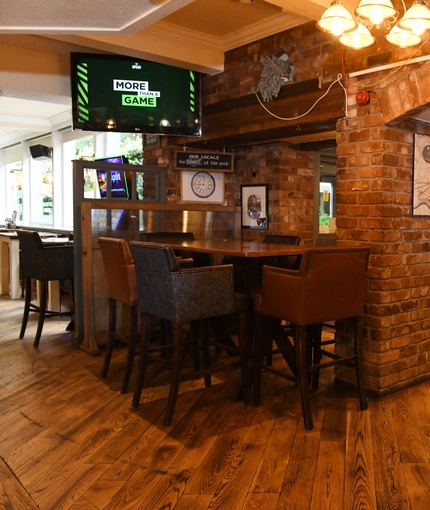 Interior dining area of a pub with a TV.