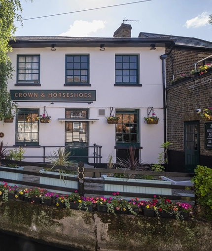 The exterior facade and waterside at The Crown & Horseshoes.