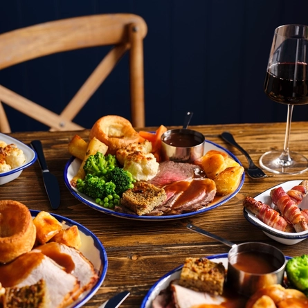 Several plated roast dinners on an indoor table.