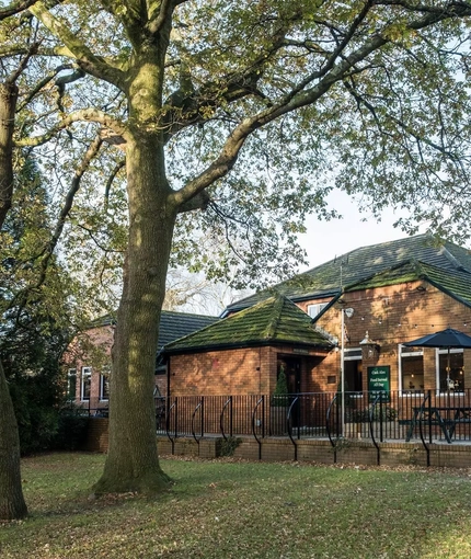 Exterior of the pub, with a tree in the foreground.