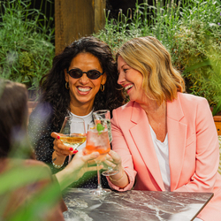 An image of people enjoying various drinks within the exterior beer garden seating area at a Crafted venue.