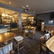 Interior dining area of a pub with a bar, a TV and gambling machines.