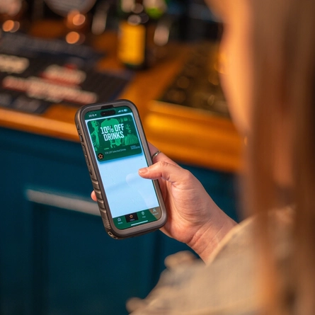 a woman showing a 10% discount on drinks available at the Greene King pubs