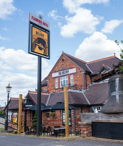 The exterior facade, signage and seating area of The Belfry in Beighton.