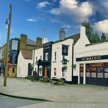 The exterior facade and outdoor seating benches at The Swan & Mitre.