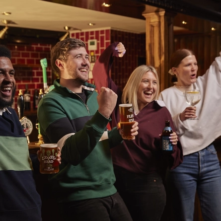 People stood at bar cheering