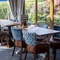 A close up view of two restaurant tables with upholstered chairs, in the conservatory area inside The Wall's End.
