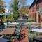 The exterior beer garden seating area at The Fox in Bury St Edmunds, with plants in raised planter boxes, and string lights above the tables and chairs.
