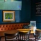 The interior restaurant seating area of the Cock & Pye, with upholstered booth seating and a TV on the wall.