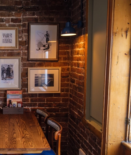 An image of one of the tables within the interior restaurant seating area with fireplace at The Guild.