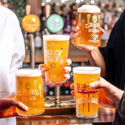 a group of people holding beers at the bar