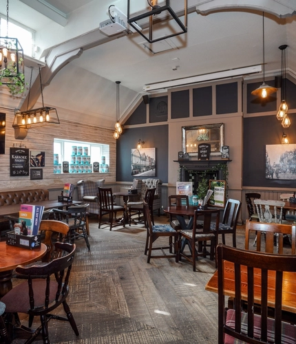 Interior dining area of a pub with a TV and a fireplace.