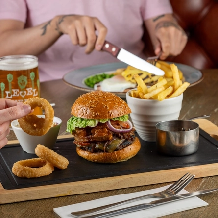 People seated at a table with plated food and drinks.