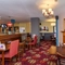 Interior dining area of a pub with a fireplace and a TV.