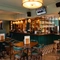 The bar and interior restaurant seating area at The Richmond Arms, with a TV on the wall, bar stool seating, and gaming machines.