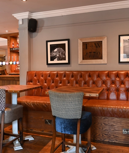 Interior seating area of a pub with a bar.