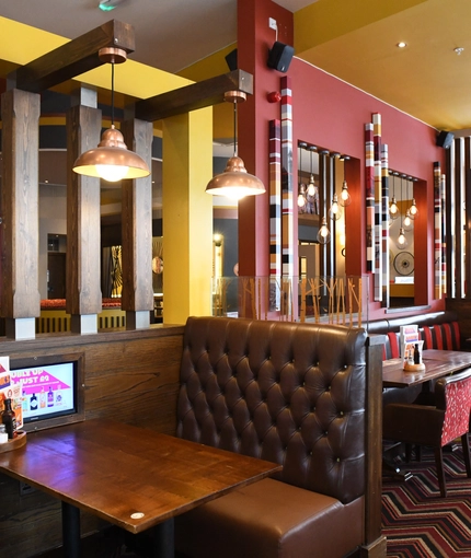 Interior dining area of a pub with a TV.